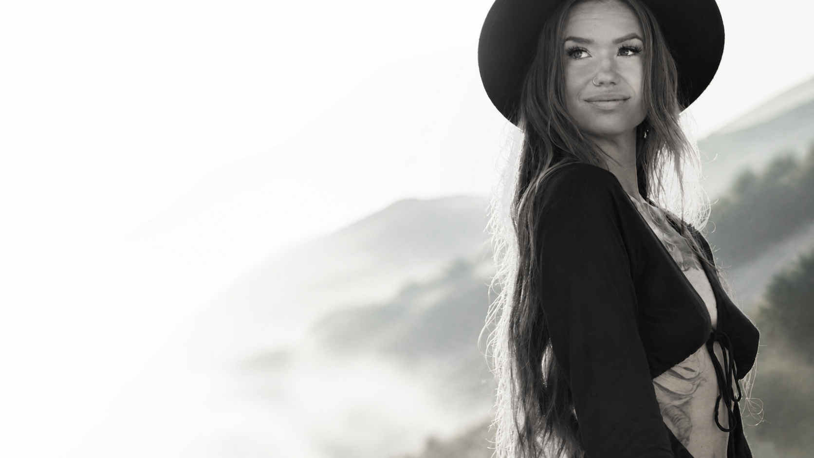 Jenna, grundare av LunaVibes Film, framför dimmiga berg